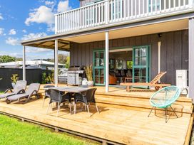 An outdoor patio with seating and a barbecue grill at Waipu in Waipu