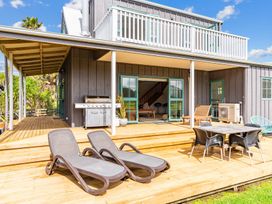 An outdoor patio with sun loungers and a table at Waipu in Waipu