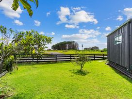 A garden with grass and trees at Waipu