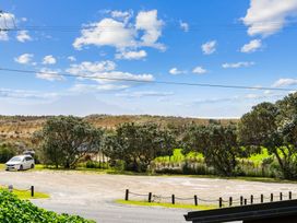 A view of a parking area with trees and grass at Waipu