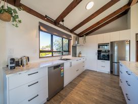 A kitchen with cabinets, sink, and dishwasher at Four Peaks on Matai - Te Anau