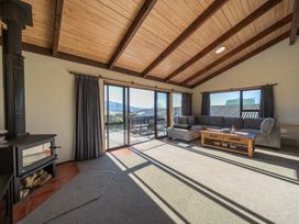 A living room with a sofa and fireplace at Four Peaks on Matai - Te Anau