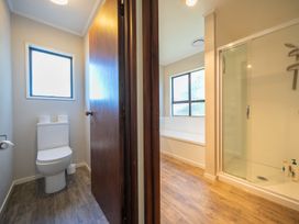 A bathroom with a toilet and shower at Four Peaks on Matai - Te Anau