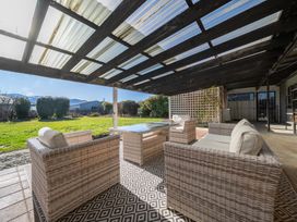 An outdoor patio with seating and a table at Four Peaks on Matai - Te Anau Holiday Home