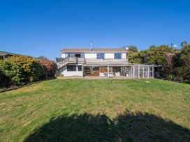 A house with a deck and yard at Four Peaks on Matai - Te Anau Holiday Home Te Anau