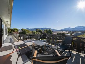 An outdoor area with chairs and a table at Four Peaks on Matai - Te Anau Holiday Home, Te Anau