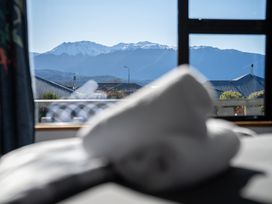 A view from a bedroom window showing mountains and rooftops at Four Peaks on Matai - Te Anau