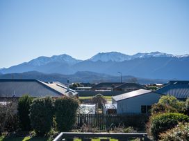 A view of mountains and houses from a balcony at Four Peaks on Matai - Te Anau Holiday Home Te Anau
