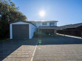 A house with a garage and driveway at Four Peaks on Matai - Te Anau