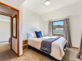 A bedroom with a bed and window at Picton Holiday Home