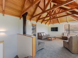 A living room with a sofa, armchairs, television and coffee table at Picton Holiday Home 