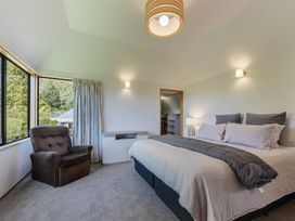 A bedroom with a bed and armchair at Picton Holiday Home