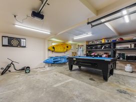 A garage with a pool table and equipment at Picton Holiday Home