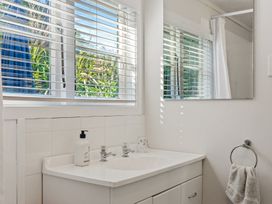 A bathroom with a sink and mirror at White-Sands Hideaway - Waihi Beach