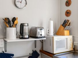 A kitchen with various kitchenware and appliances at White-Sands Hideaway - Waihi Beach