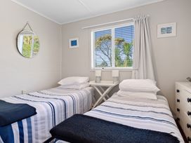 A bedroom with two beds and a window at White-Sands Hideaway - Waihi Beach