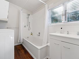 A bathroom with a bathtub and sink at White-Sands Hideaway - Waihi Beach