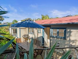 An outdoor area with a table and umbrella at White-Sands Hideaway - Waihi Beach