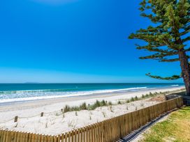 A beach view with ocean and tree at White-Sands Hideaway - Waihi Beach