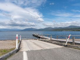A dock leading to water with mountains in the background