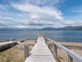 A dock extending into the water with mountains in the background