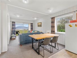 A living room with a sofa, table, and chairs at a property