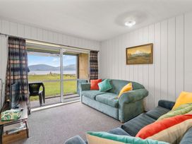 A living room with a television and a view of the outdoor area at the property