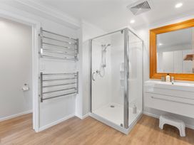 A bathroom with a shower, mirror, and sink at 