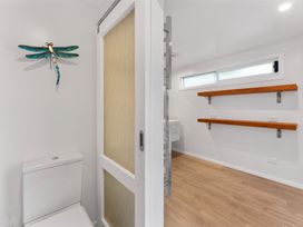 A bathroom with a toilet, shelves, and a decorative piece at the property in 