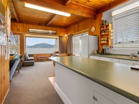 A kitchen with a counter, refrigerator, and sofa at a property by the lake