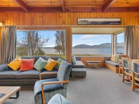 A living room with a sofa, chairs, and a lake view at a property