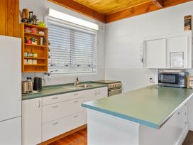 A kitchen with a counter, sink, shelves, and various appliances at 