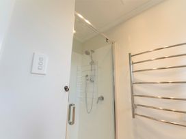 A shower enclosure with a glass door in a bathroom