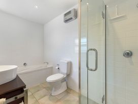 A bathroom with a bathtub, toilet, and shower at Waikawa Holiday Home