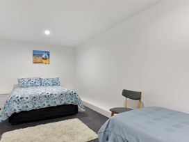 A bedroom with a bed and a chair at Waikawa Holiday Home