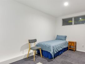 A bedroom with a bed and chair at Waikawa Holiday Home