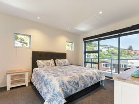 A bedroom with a bed and windows at Waikawa Holiday Home