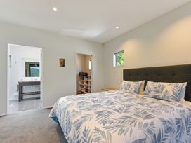 A bedroom with a bed and adjoining bathroom at Waikawa Holiday Home 