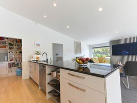 A kitchen with a sink and pantry with shelving at Waikawa Holiday Home