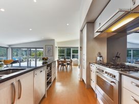 A kitchen with a stove, sink and a dining area at Waikawa Holiday Home