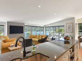 A living room with a television and large windows at Waikawa Holiday Home