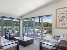 A living room with a view of the water and mountains at Waikawa Holiday Home