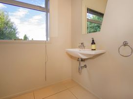 A bathroom with a sink and mirror at Bay View Escape - Whitianga Holiday Home Whitianga