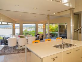A living room with a view of the water and mountains at Bay View Escape - Whitianga Holiday Home