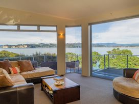 A living room with a view of water and trees at Bay View Escape - Whitianga Holiday Home, Whitianga