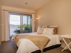 A bedroom with a bed and a window at Bay View Escape - Whitianga