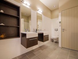 A bathroom with double sinks and mirrors at Bay View Escape - Whitianga Holiday Home