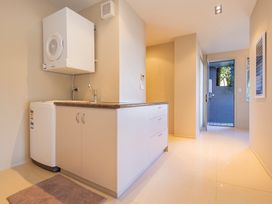 A laundry room with a washing machine and countertop at Bay View Escape - Whitianga