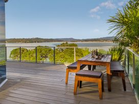 A deck with a wooden table and benches at Bay View Escape - Whitianga Holiday Home Whitianga