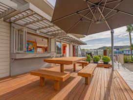 An outdoor seating area with a table and bench at Whangapoua